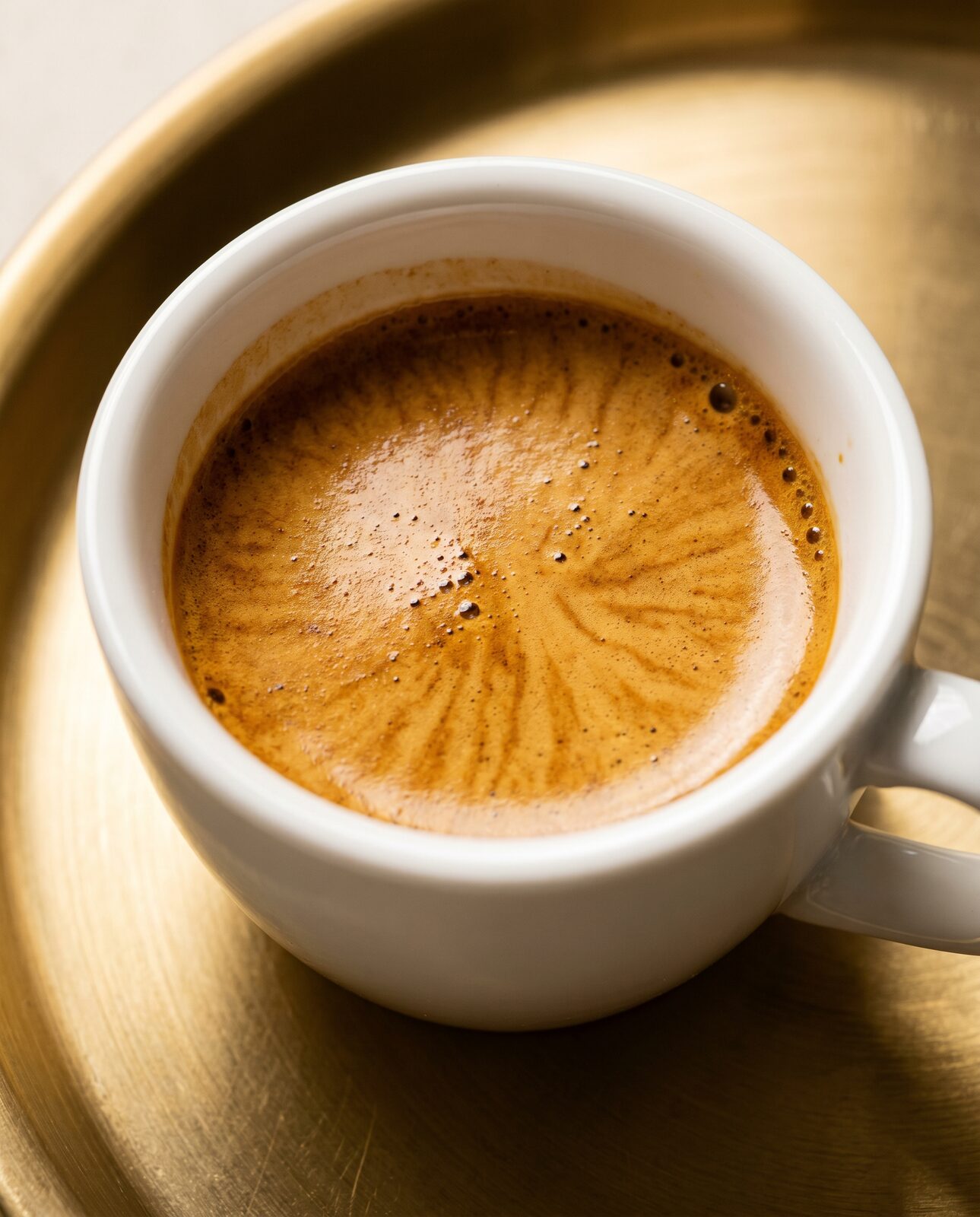 Close-up of fresh golden espresso crema in a cup